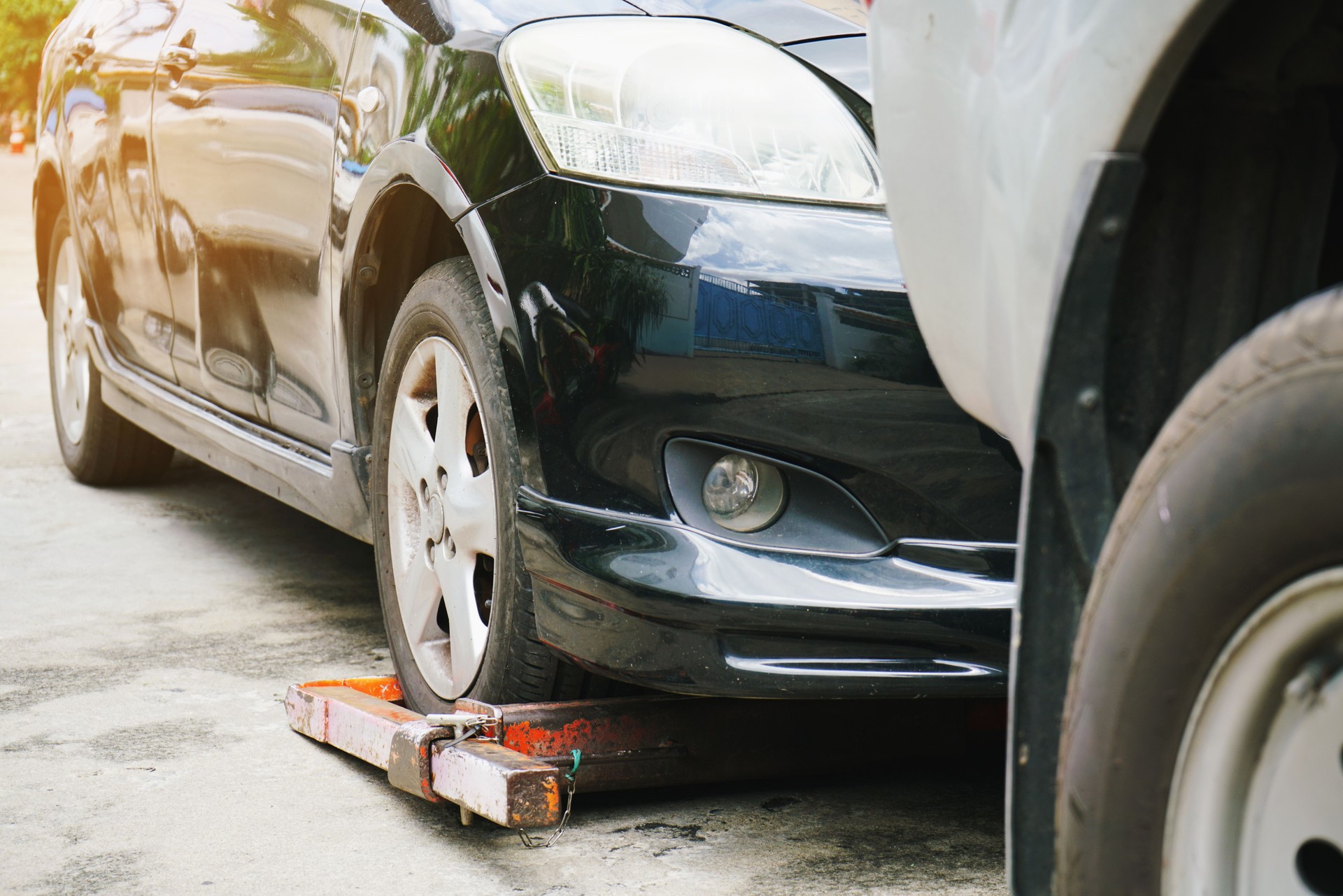 Tow truck picking up and towing broken down car on a roadside